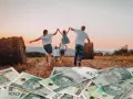 Rodzina biegnie przez pole ku zachodzącemu słońcu, a pod stopami leżą banknoty 100 zł. Wniosek 800 plus do kiedy?