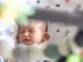 Śpiące dziecko na kocyku w gwiazdki. Może to być moment regresu snu, kiedy maluch potrzebuje więcej spokoju.