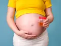 Ciężarna kobieta trzyma pojemnik z próbką moczu, badanie na obecność ketonów w moczu w ciąży.