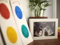 Obraz USG, na którym widać, kiedy zaczyna bić serce płodu, obok kolorowych kółek i tęczy.
