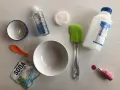 Składniki do zrobienia slime bez kleju: soda, płyn do soczewek, brokat, miski, łopatka i barwnik.