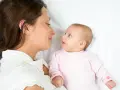 Mama patrzy na swoje dziecko, kiedy noworodek widzi świat po raz pierwszy.