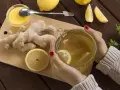 Kobieta pije herbatę z imbirem i cytryną, która pomaga w dolegliwościach w ciąży.