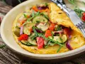 Puszysty omlet dla niemowlaka z cukinią, pomidorkami, oliwkami i rukolą. Zdrowy i kolorowy posiłek.
