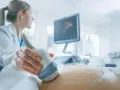 Lekarka wykonuje USG brzucha ciężarnej, monitorując przebieg ciąży. Badanie to jest kluczowe, zwłaszcza gdy stosowana jest heparyna w ciąży.