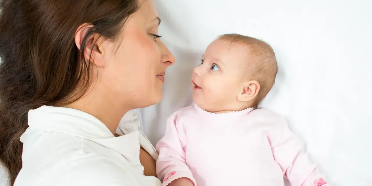 Mama patrzy na swoje dziecko, kiedy noworodek widzi świat po raz pierwszy.