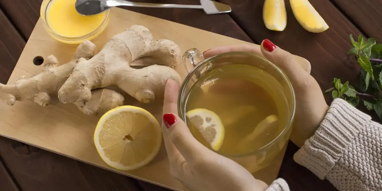 Kobieta pije herbatę z imbirem i cytryną, która pomaga w dolegliwościach w ciąży.