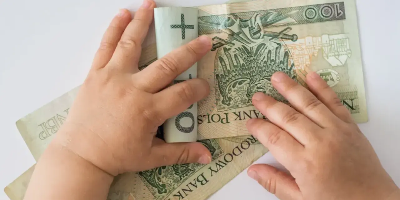 Dziecko bawi się banknotami 100 zł. Czy to już 12 tys na dziecko?