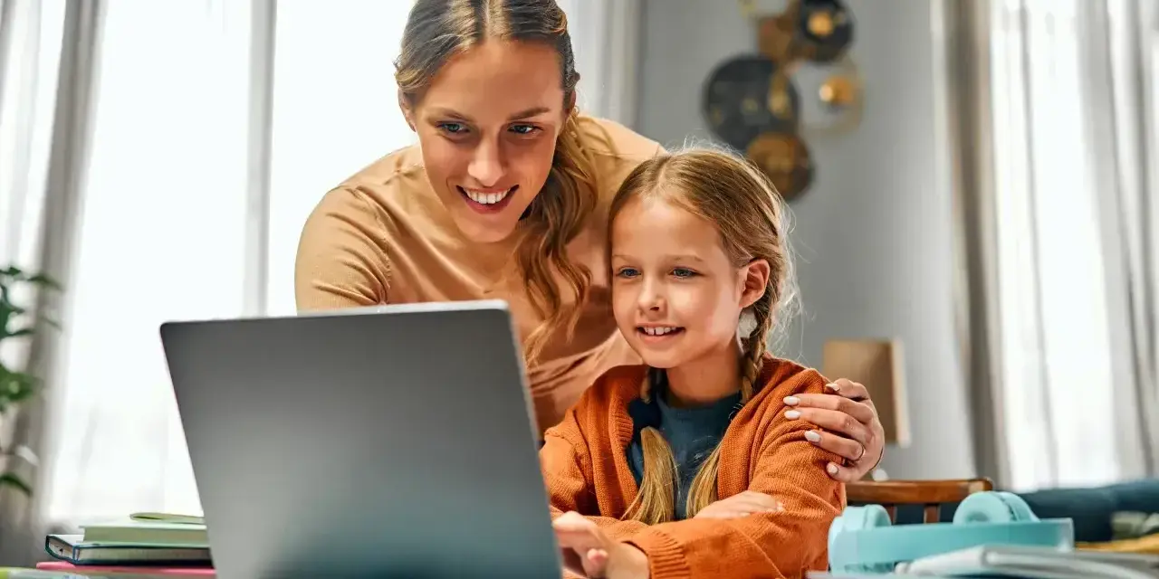 Mama pomaga córce w nauce online. Dni opieki na dziecko mogą być pełne wspólnych chwil przy komputerze.