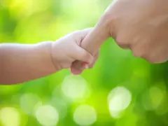 Dłoń dziecka i dorosłego splatają się. Symbol siły i miłości, często interpretowany jako obraz osoby samotnie wychowującej dziecko.