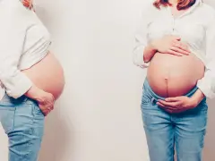 Dwa zbliżenia na ciążowe brzuchy. Kobiety w białych koszulach i dżinsach. Każdy kształt brzucha w ciąży jest unikalny.