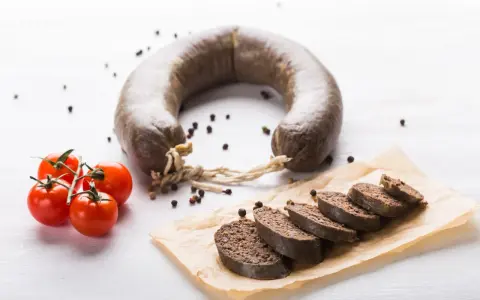 Kaszanka w ciąży, podana z pomidorkami i pieprzem. Smaczny i sycący posiłek.