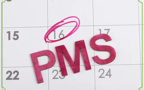 Litery PMS na kalendarzu. Dzień 16 zaznaczony kółkiem, sugerując fałszywe objawy ciąży.