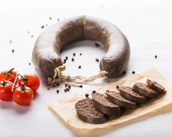 Kaszanka w ciąży, podana z pomidorkami i pieprzem. Smaczny i sycący posiłek.