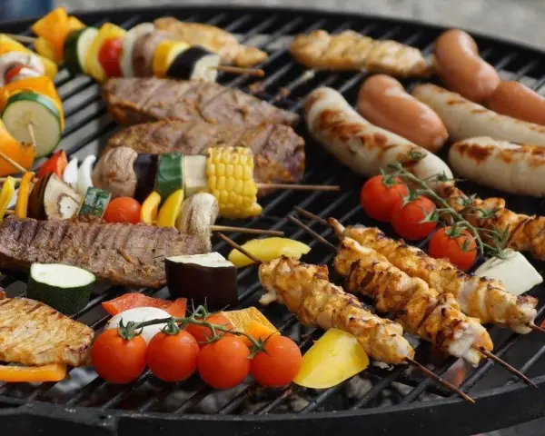 Kolorowe szaszłyki z warzywami i kurczakiem, kiełbaski i mięso na grillu – idealne co na grilla dla dzieci i dorosłych.