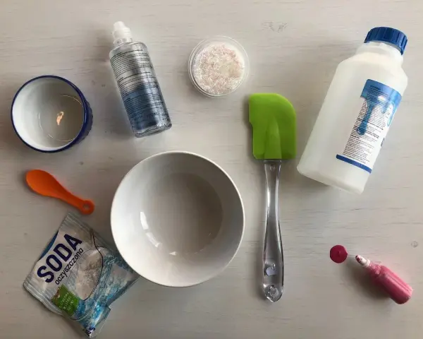 Składniki do zrobienia slime bez kleju: soda, płyn do soczewek, brokat, miski, łopatka i barwnik.
