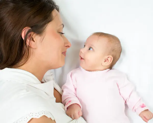 Mama patrzy na swoje dziecko, kiedy noworodek widzi świat po raz pierwszy.