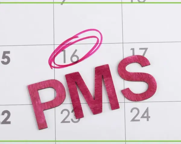 Litery PMS na kalendarzu. Dzień 16 zaznaczony kółkiem, sugerując fałszywe objawy ciąży.