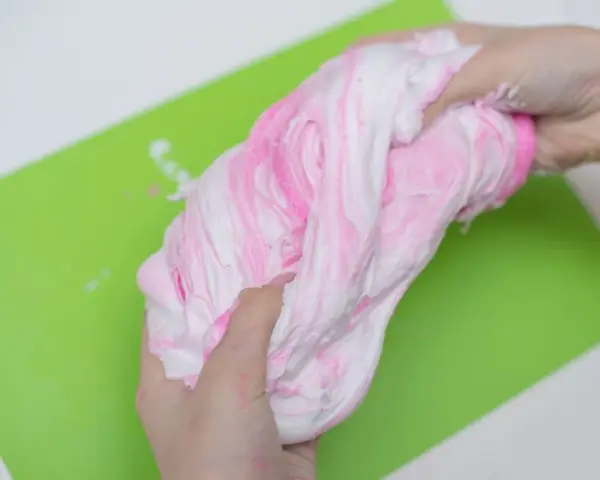 Różowy i biały slime z pianki do golenia, idealny do zabawy. Dowiedz się, jak zrobić slime z pianki do golenia!