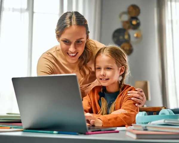 Mama pomaga córce w nauce online. Dni opieki na dziecko mogą być pełne wspólnych chwil przy komputerze.