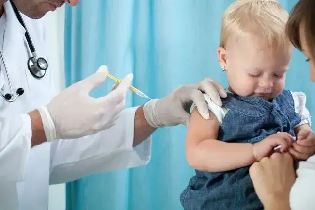 Pediatra bada dziecko przed szczepieniem