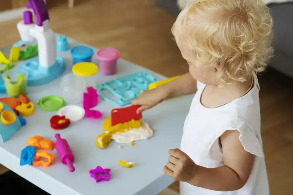 dziecko bawi się masą sensoryczną w domu