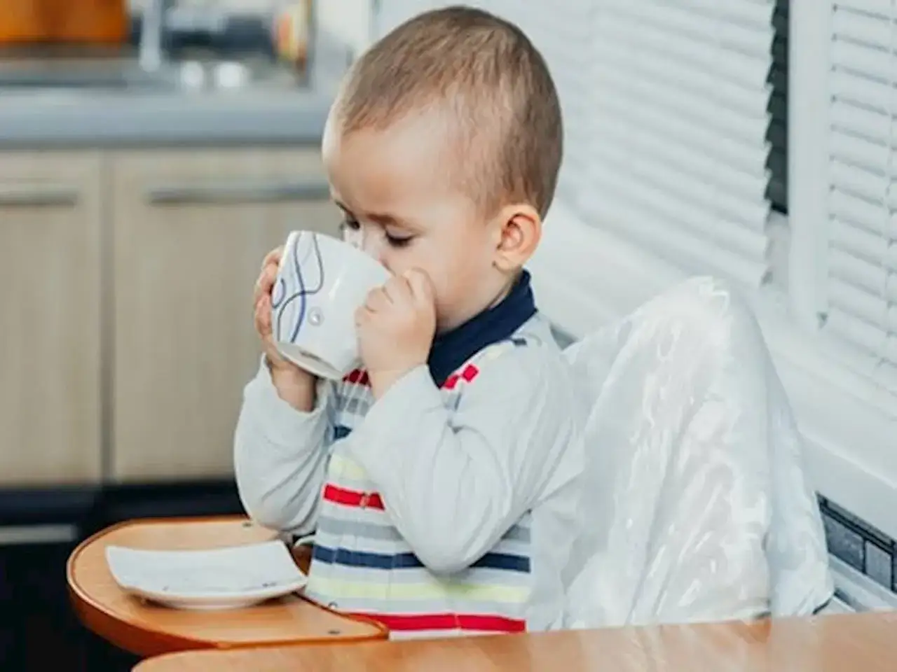 dziecko pije mleko z kubka